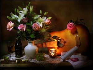 Róże i lilie w wazonie obok gitary, świecy i winogron