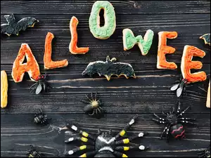 Nietoperze i pająki przy napisie Halloween z ciasteczek