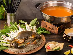 Krab na makaronie obok garnka z zupą krabową