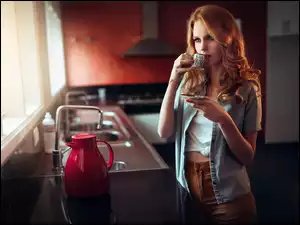 Kobieta w kuchni pije poranną kawę