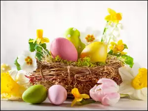 Wielkanocna kompozycja z pisankami i kwiatami w koszyczku