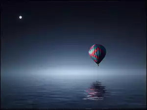 Balon podczas nocnego rejsu nad wodą