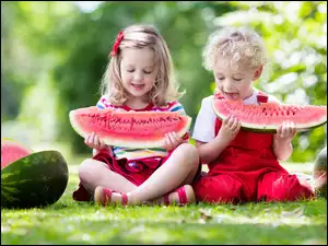 Dzieci z arbuzami na łące