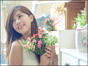 Uśmiechnięta dziewczyna z bukietem pięknych kwiatów