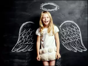 Dziewczynka z skrzydłami anioła przy tablicy