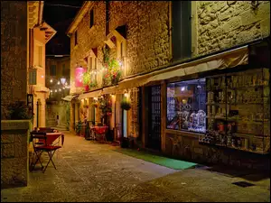 Stoliki na ulicy przed kawiarnią w San Marino nocą