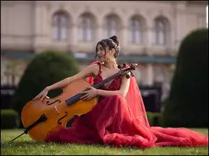 Kobieta w czerwonej sukience z wiolonczelą
