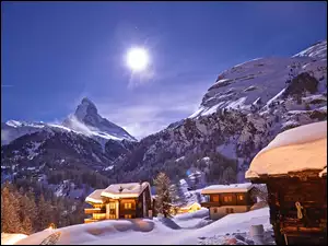 Zimowe słońce opromienia góry i domy w dolinie