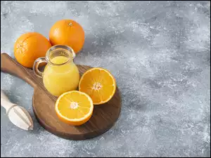 Dzbanek z sokiem i pomarańcze na desce