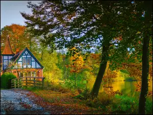Dom nad jeziorem otoczonym jesiennym lasem