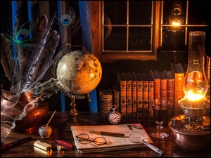 Lampa naftowa oświetla książki, globus i inne gadżety na stole