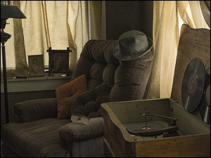 Gramofon z fotelem kapeluszem i lampą