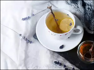 Filiżanka herbaty z cytryną obok miodu