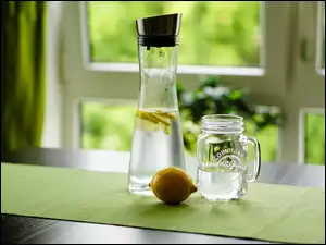 Woda z cytryną w butelce obok słoika