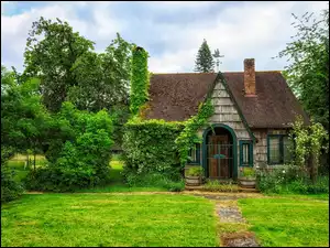 Dom okryty bluszczem w zielonym ogrodzie