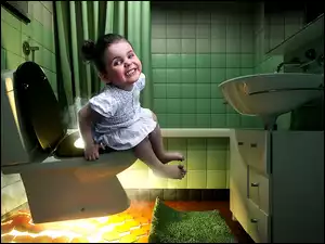 Mała dziewczynka siedzi na podświetlonym sedesie w łazience