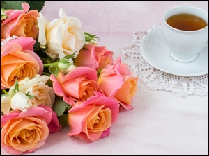 Filiżanka herbaty obok wiązanki róż