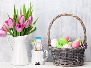 Dzbanek z tulipanami pędzle i pisanki w koszyku