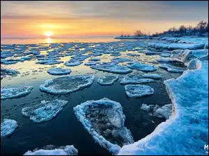 Lód i kry lodowe na jeziorze o wschodzie słońca