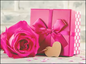 Serduszko obok prezentu i różowej róży