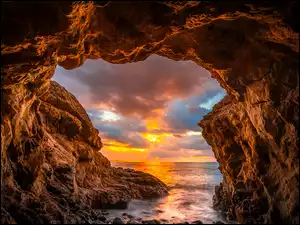 Łuk skalny nad morzem o zachodzie słońca