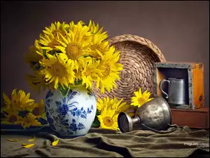 Puchar i kufel obok słoneczników w malowanym wazonie