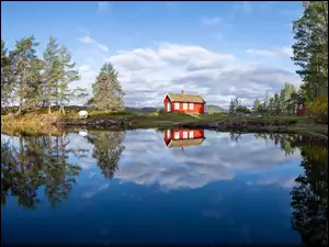 Czerwony domek na brzegu jeziora
