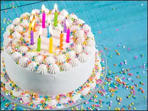 Urodzinowy tort ze świeczkami na niebieskich deskach
