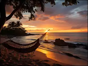 Hamak na drzewie na plażyo zachodzie słońca