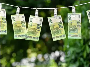 100 euro w banknotach wiszą przypięte klamerkami na sznurku