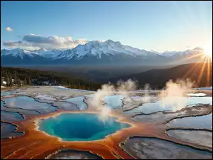 Góry ze śniegiem nad głębią jeziora w promieniach słońca