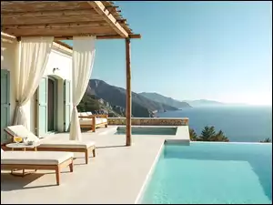 Dwa leżaki nad basenem na tarasie domuz widokiem na morze