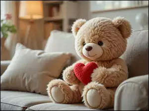 Siedzący pluszowy miś z sercem na sofie